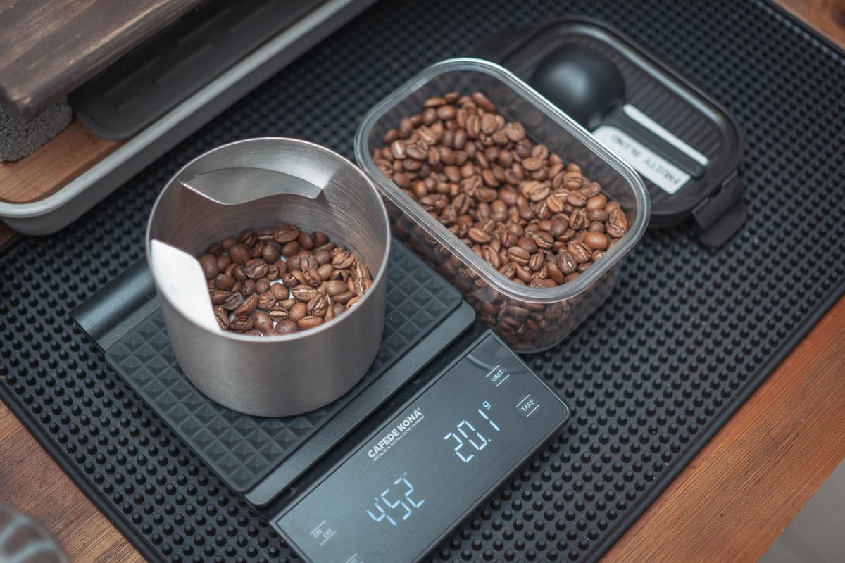 Illustrative stock photo: coffee beans being weighed on a digital kitchen scale
